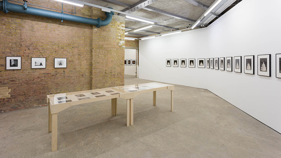 A photo of the basement gallery at the CCA with a long table and exposed brick wall