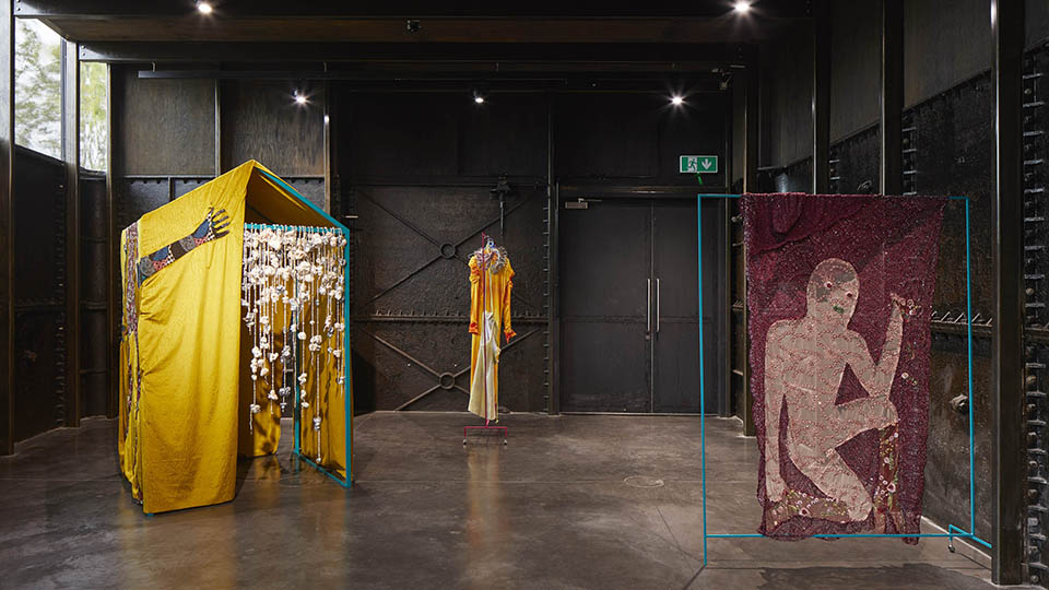 An abstract fabric exhibition inside a dark room in the Daskalopoulos Gallery at the CCA