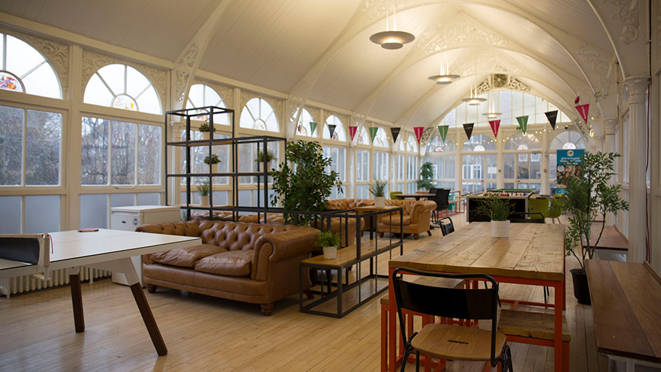 The orangery communal area with sofas and chairs and large windows in Surrey House