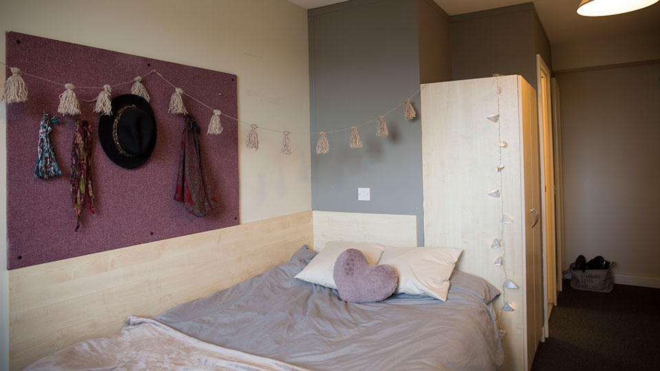 A bedroom with notice board inside Quantum Court