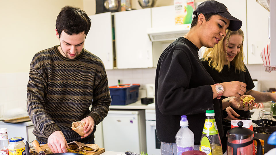 Students cooking in a shared kitchen inside Loring Hall